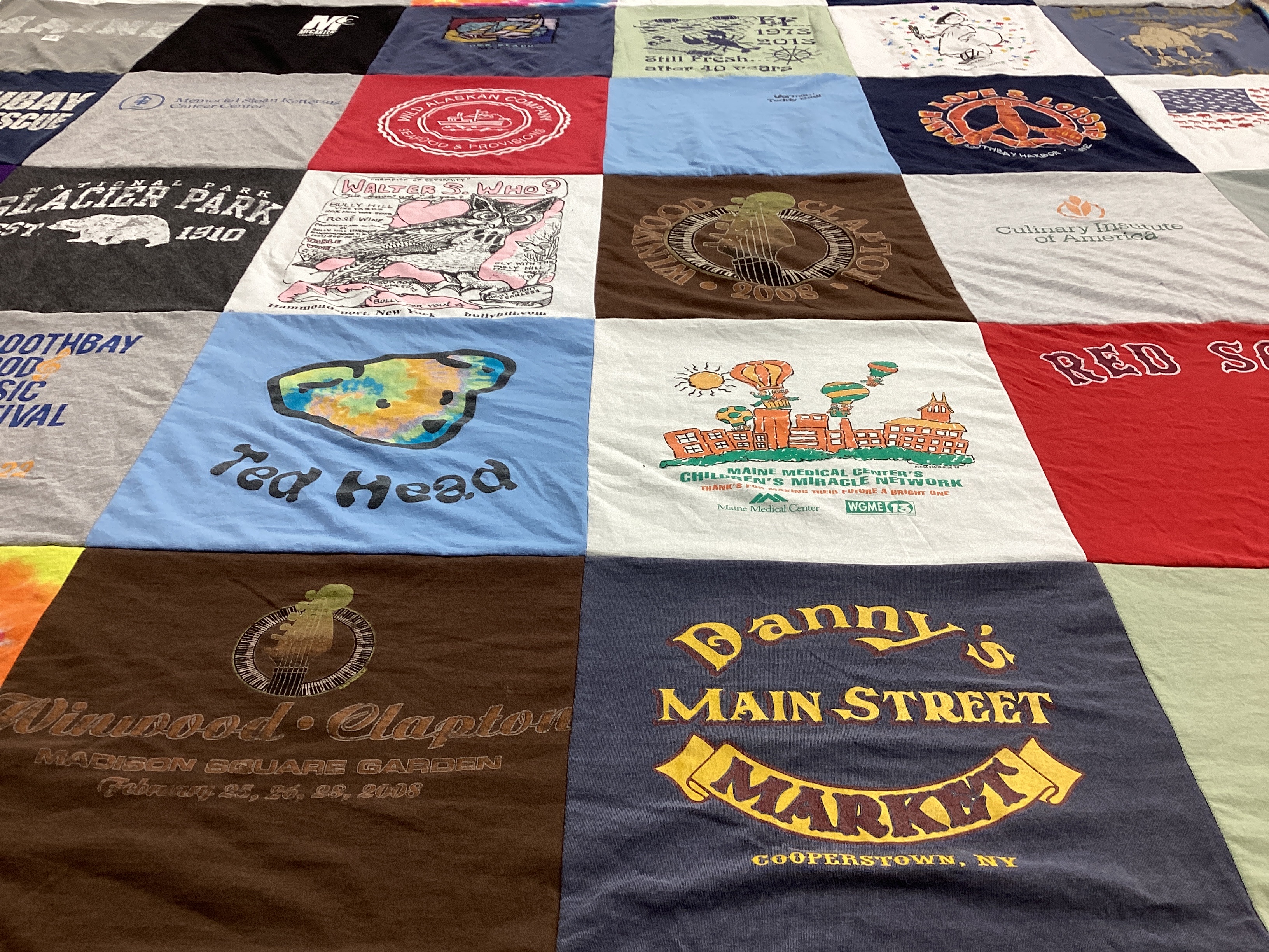 T-shirt quilt with music festivals, cooking themes by Mary from NJ
