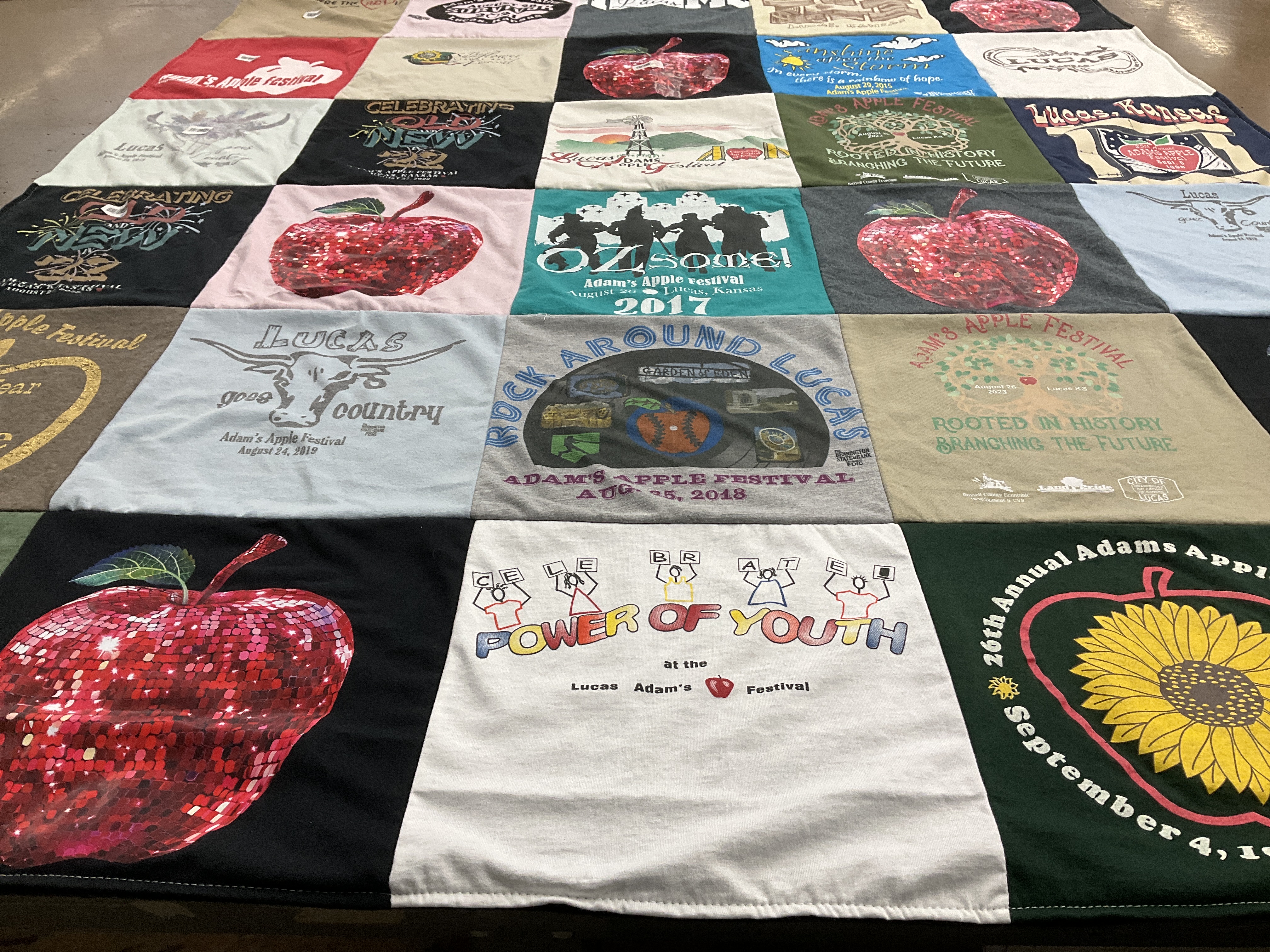 T-shirt quilt with community events, festivals themes by Rita from KS
