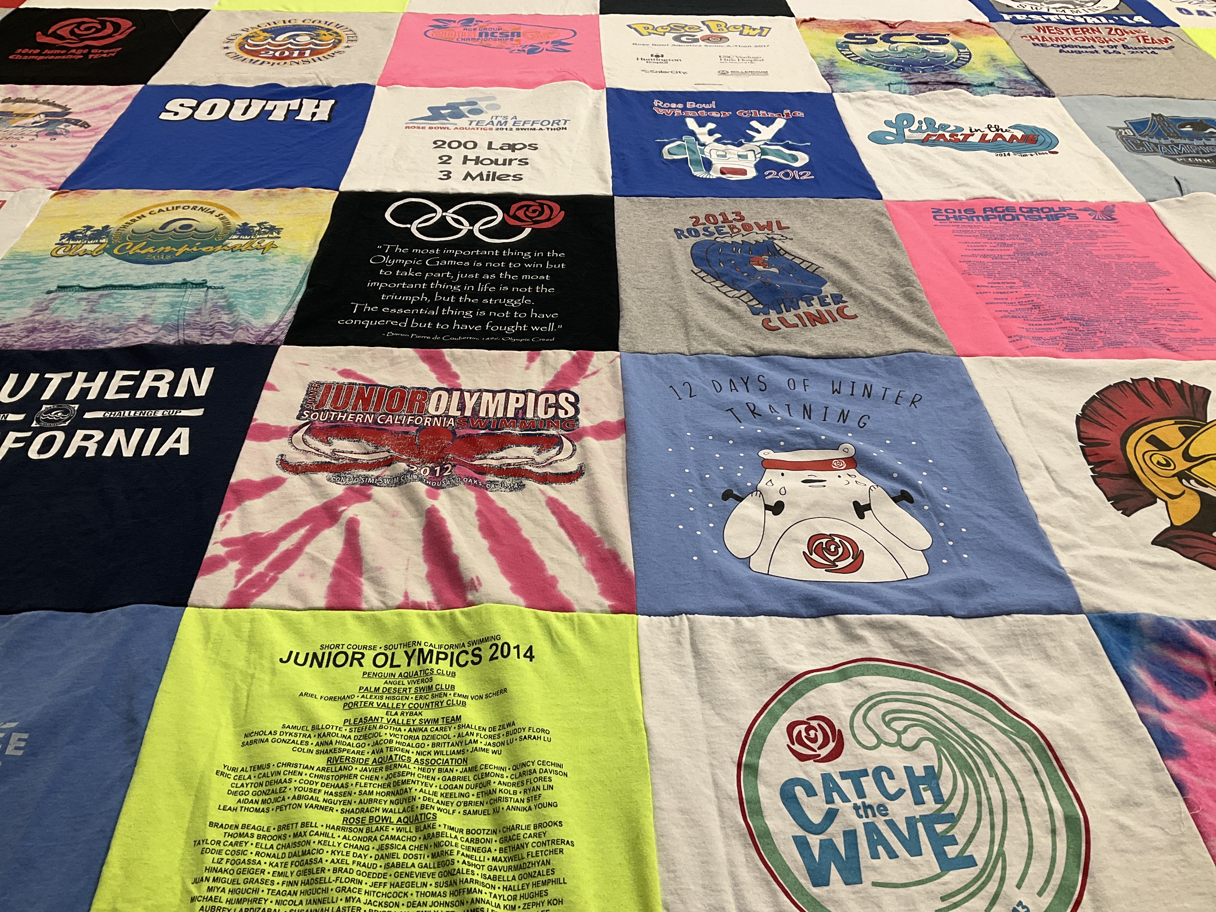 Custom Project Repat t-shirt quilt highlighting swimming, sports themes.