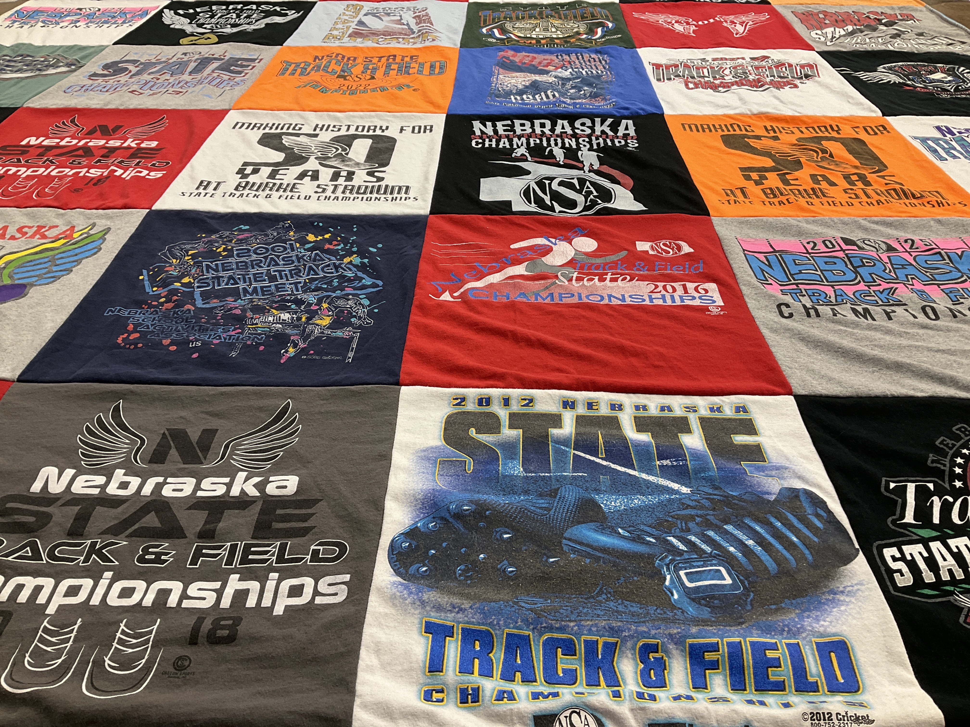 Custom Project Repat t-shirt quilt highlighting track and field, sports themes.