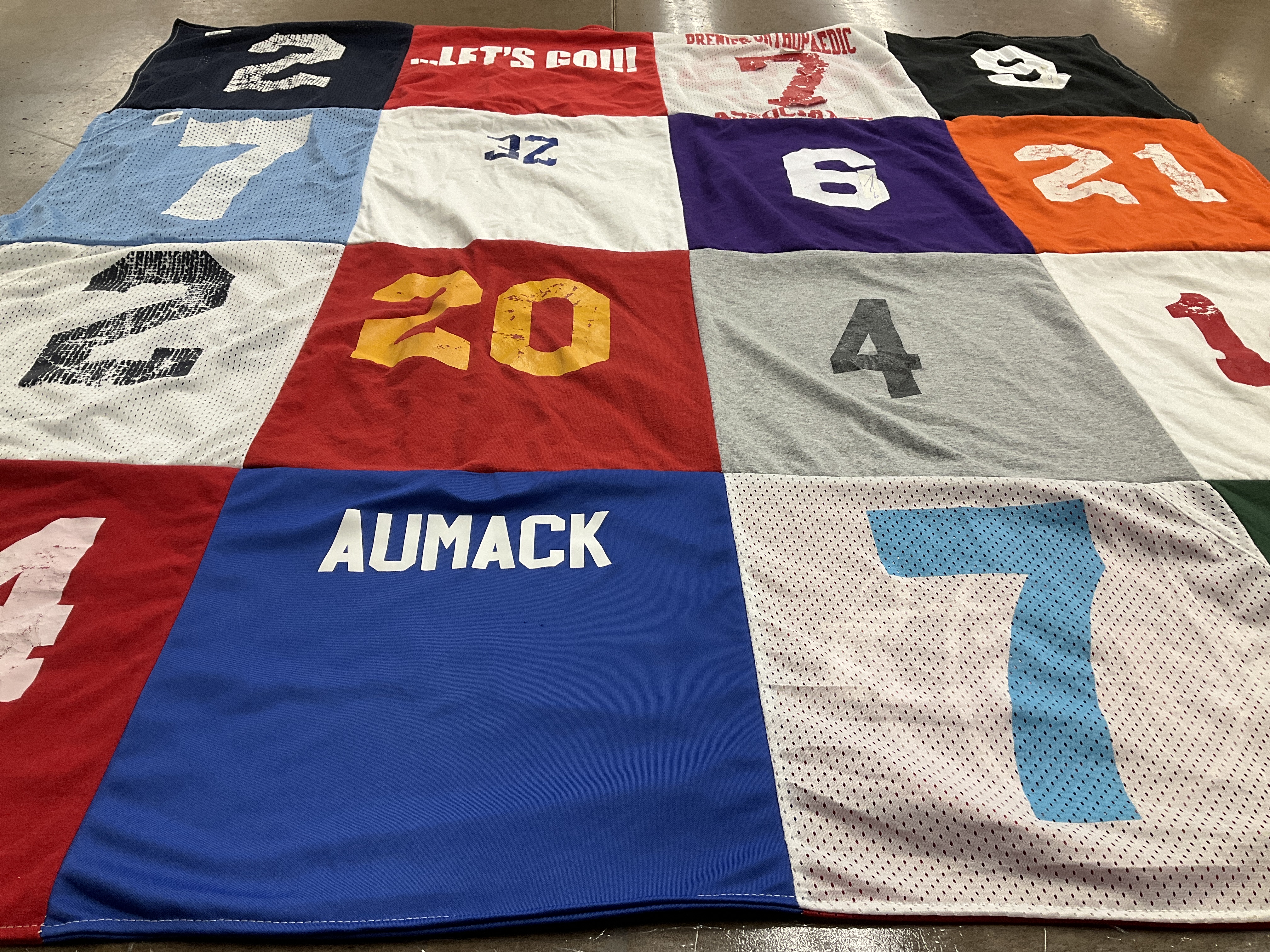 Custom Project Repat t-shirt quilt made from shirts with text like “let's”, “aumack”.