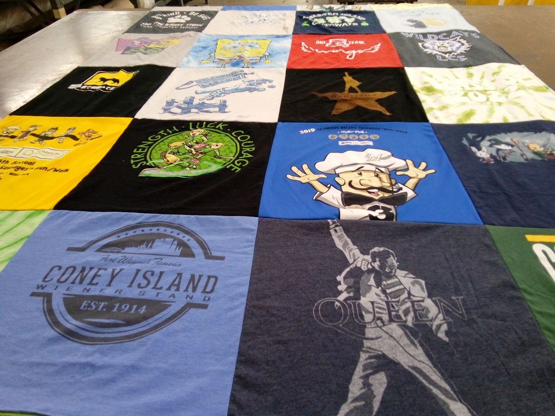 T-shirt quilt with cartoons, musical themes by Gregory from WI