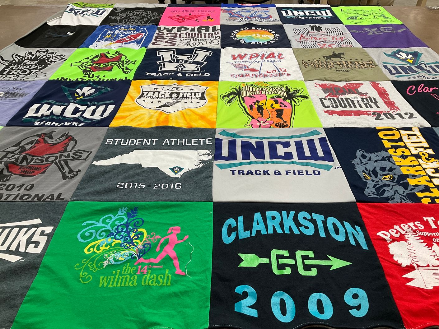 T-shirt quilt featuring clarkston high school cross country, university of north carolina wilmington seahawks track and field by Kylie from NC