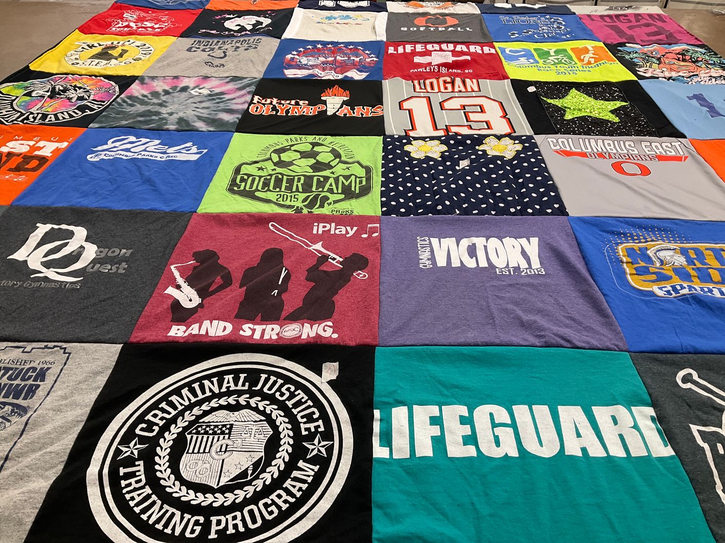 T-shirt quilt with gymnastics, soccer themes by Heather from IN