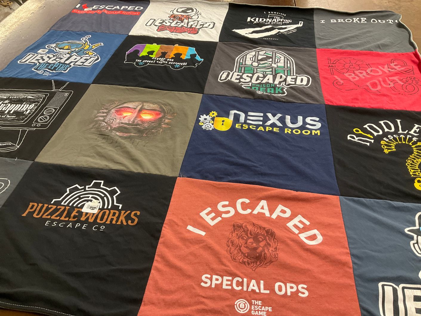 T-shirt quilt with escape rooms, puzzles themes by Jeni from MN