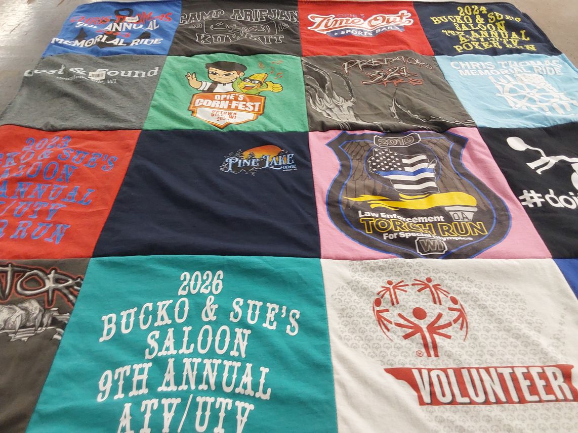 T-shirt quilt with community events, fundraising themes by Susan from WI