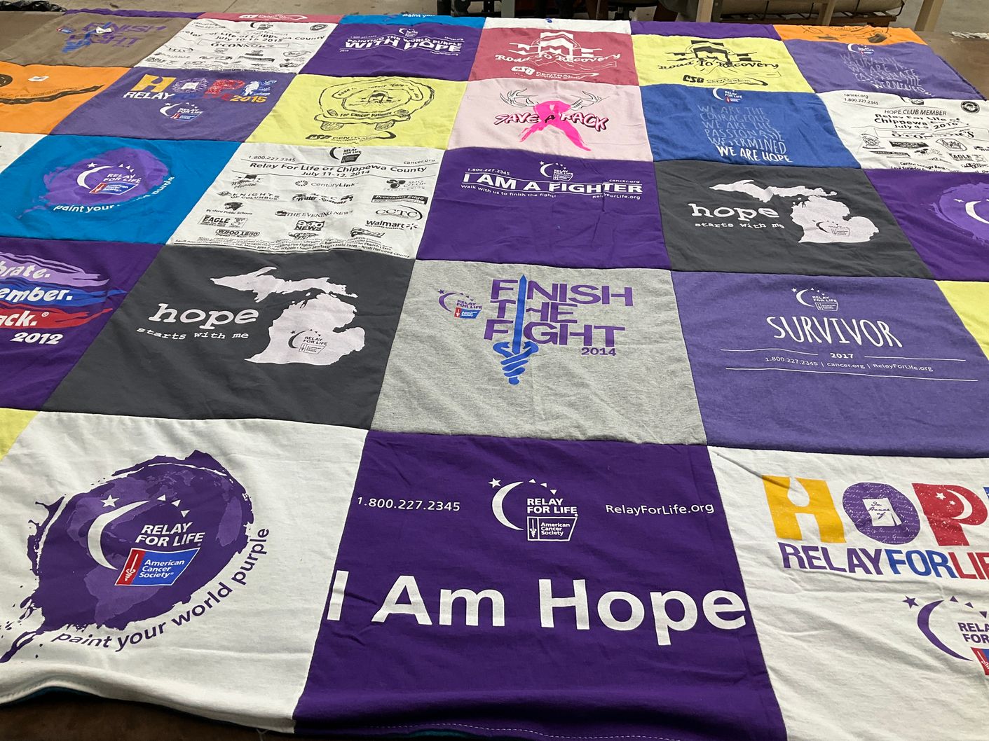 T-shirt quilt with cancer awareness, community support themes by Gladys from MI